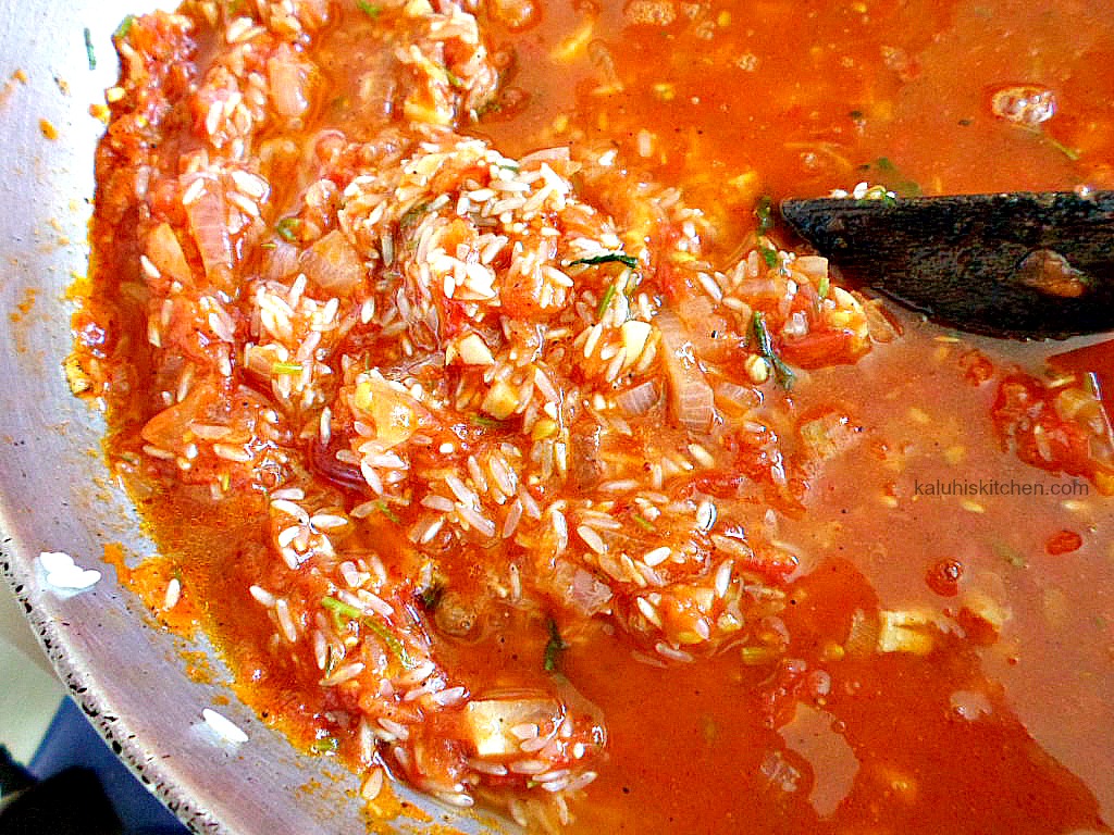 adding rice to tomato sauce for jollof