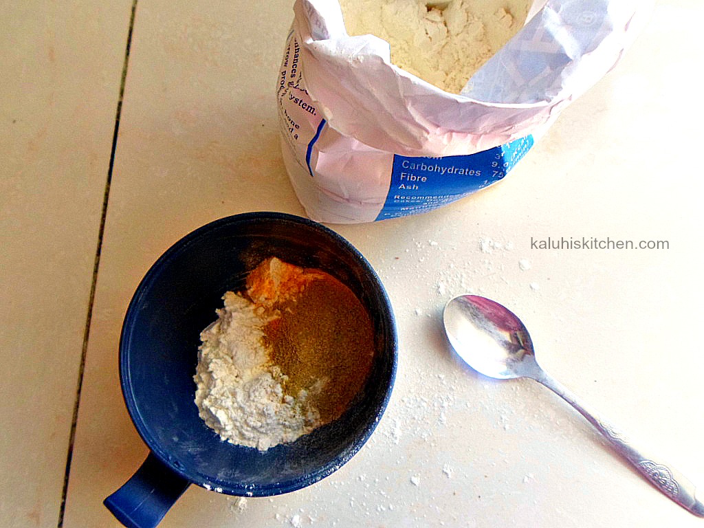 making batter for viazi karai with flour, tumeric and garlic powder