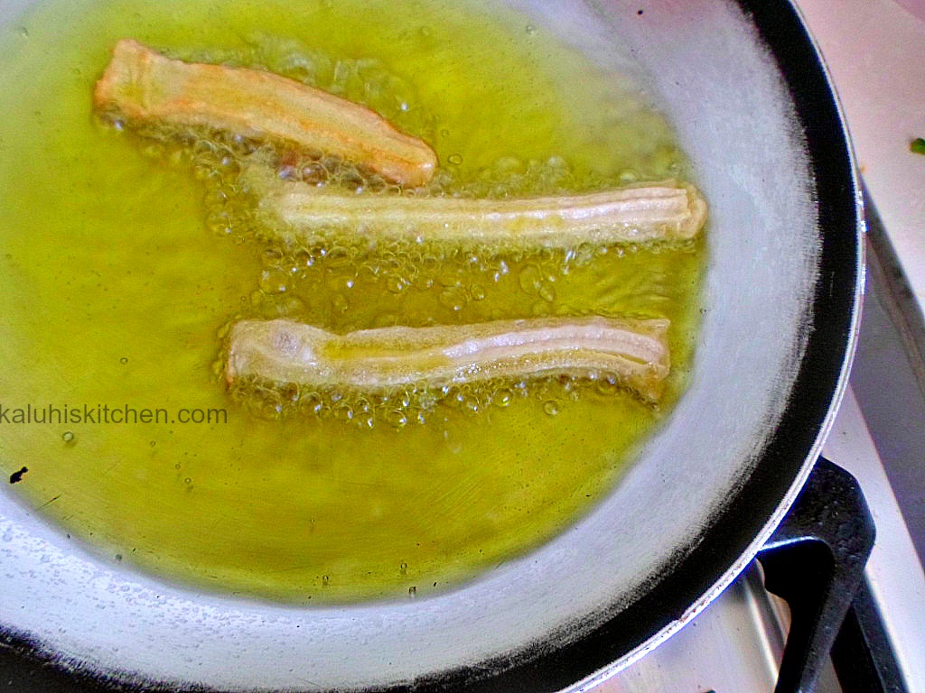 churros frying in the oil until golden brown