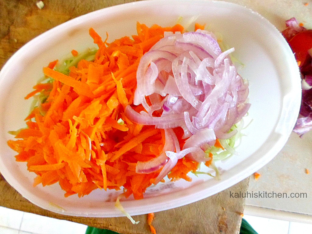 mixing carrots, cabbage onion, green apple and mango for a coleslaw