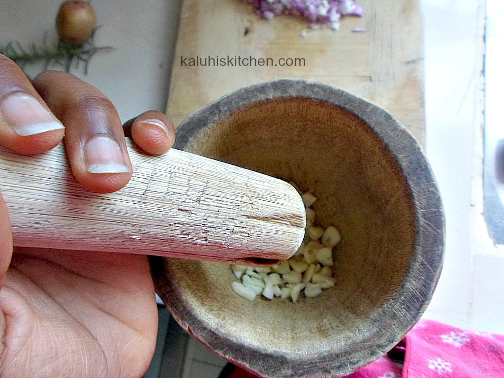 pounding garlic with a pestle and mortar or a kinu as Kenyans call it