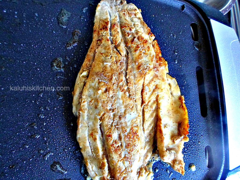 frying the fish, about 5 minutes on each side until the flesh turns white_do not remove the clinging pieces of garlic_Kaluhis Kitchen