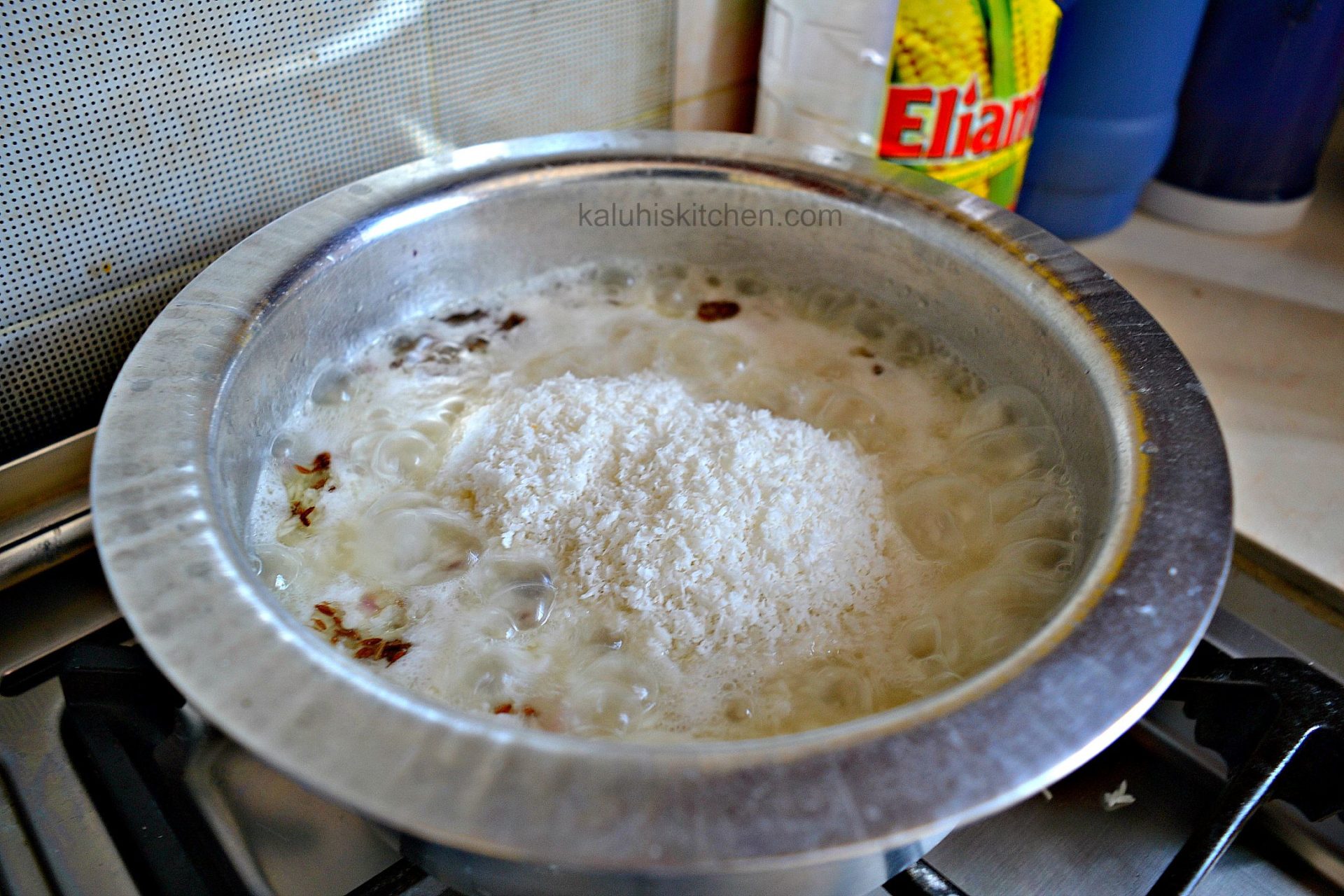 add the coconut to the rice when the water level has decreased by 14_mix it in and cover co finish cooking_wali wa nazi_kaluhiskitchen.com