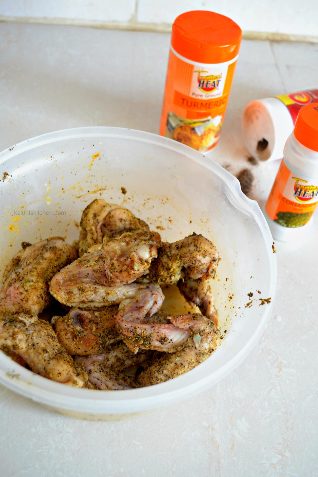 seasoning chicken with coriander powder, turmeric and black pepper for my brandy marinated chicken wings_kaluhiskitchen.com