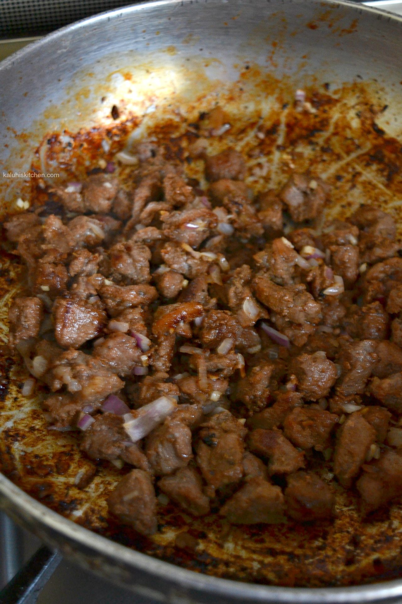 add the red onion in the rendered plum marinated pork and sautee for about 5 minutes_kenyan food blogger_kaluhiskitchen.com