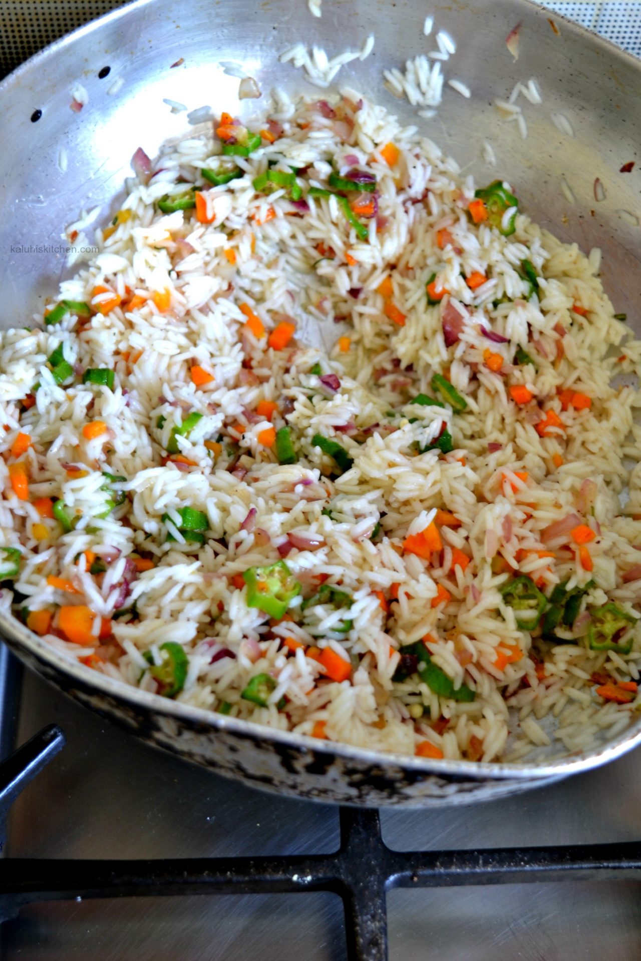 mix inthe cooked rice with the vegetables and mix it in until it is evenly distributed_rosemary and okra fried rice_kaluhiskitchen.com