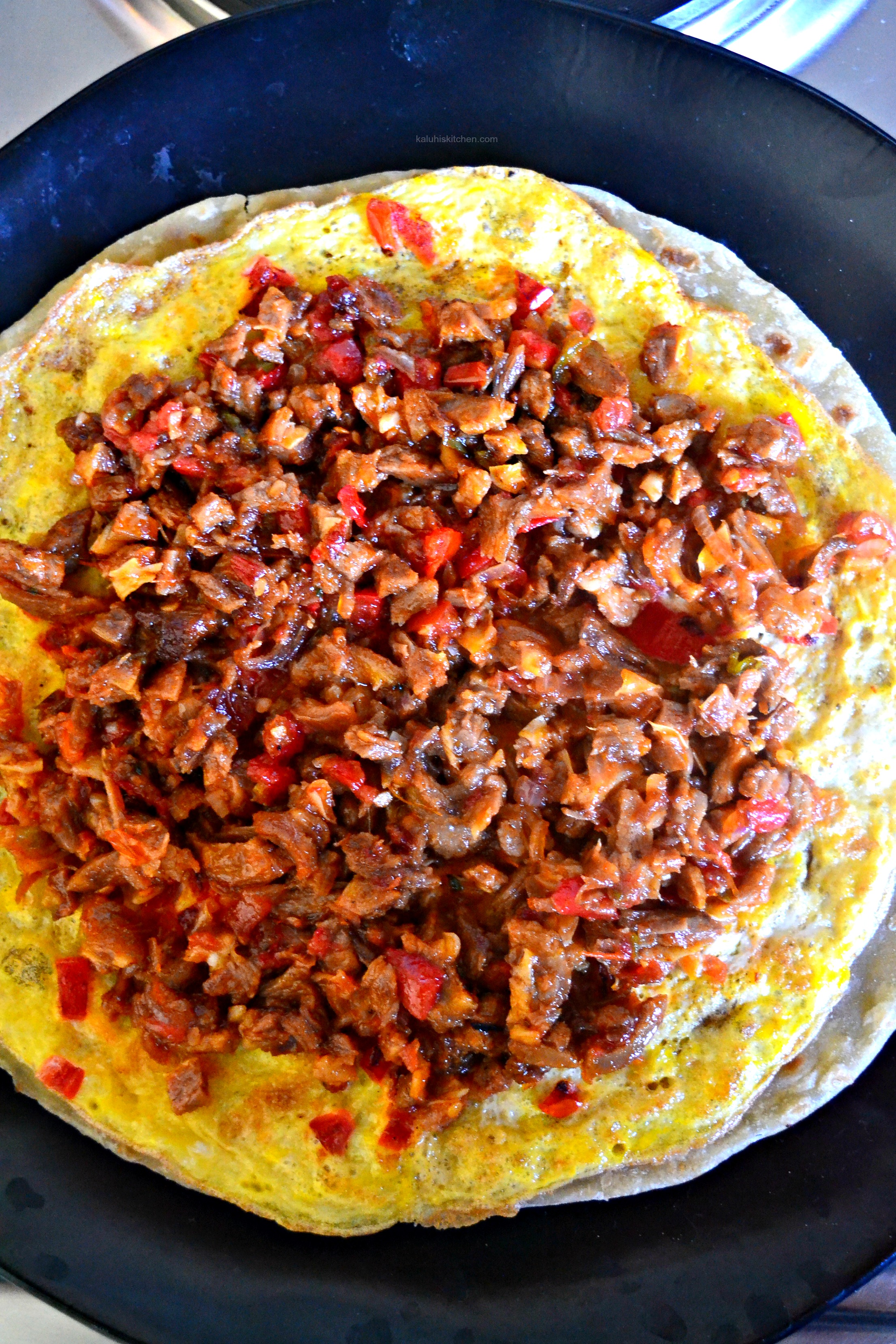 add-the-third-layer-the-meat-over-the-omelette-and-spread-it-over-with-majotrity-being-toward-the-center_kaluhiskitchen-com