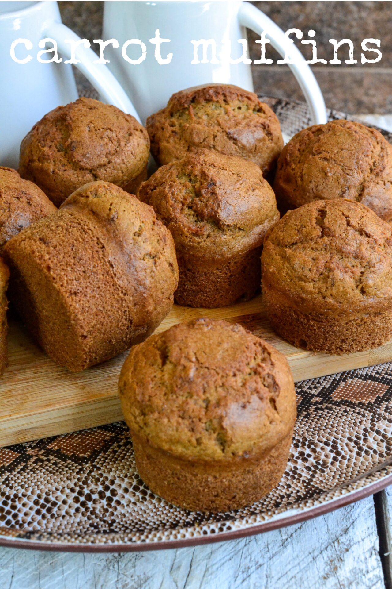 Super soft, freshly baked carrot muffins with visible carrot pieces and very soft and spongy, placed on a tray with tea cups ready to eat